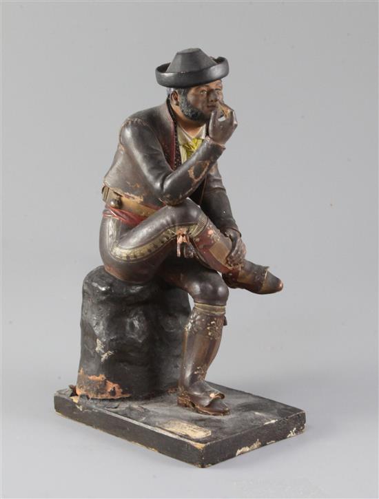 A 19th century Spanish polychrome painted terracotta figure of a seated gentleman smoking a pipe, height 10in.